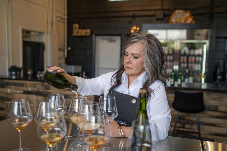 Kari Williams pours a flight of Snow Capped Cider for guests of the cidery.