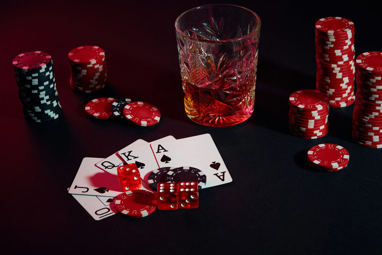 Poker cards, chips, dice for casino games, and a glass of beer