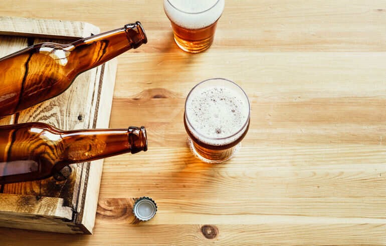 Bottles and glasses with homebrews on a wooden table