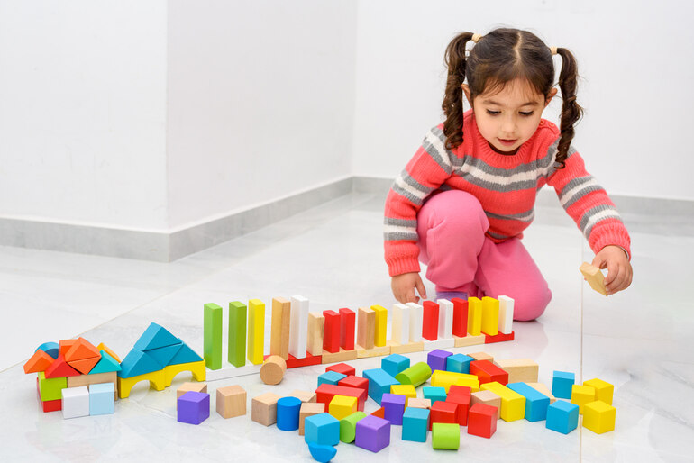 A child playing with colorful Montessori toys, helpful for creativity and cognitive development