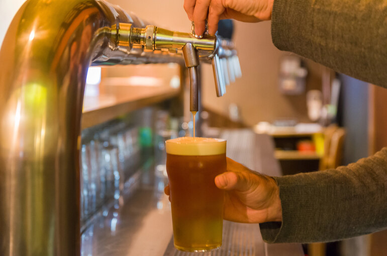 Someone is pouring a pint of craft beer at a brewery taproom in NYC