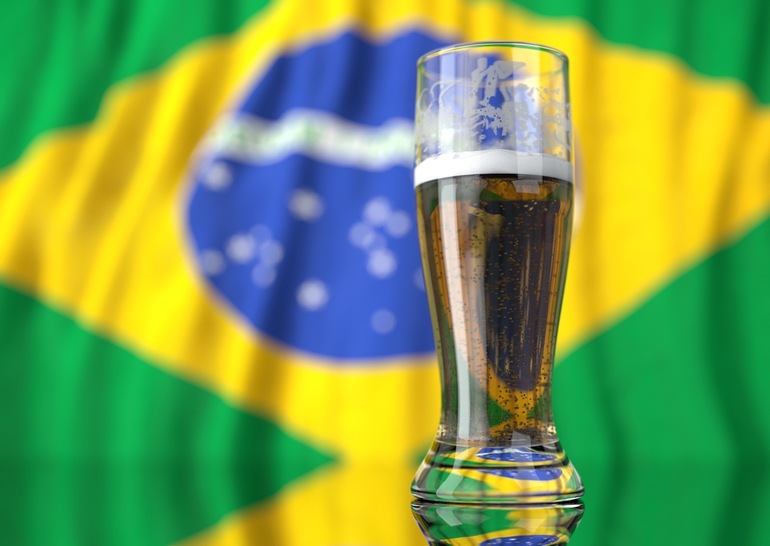 A glass of beer in front of a Brazilian flag