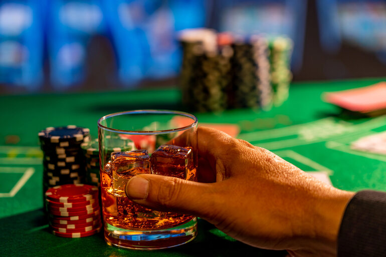 A gambler drinking while gambling at a casino