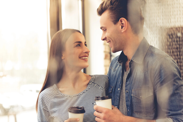 Happy and smiling young couple in a cafe having coffee