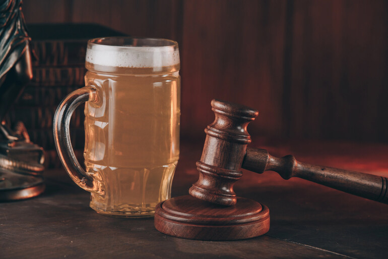 A glass of beer next to a judge's gavel