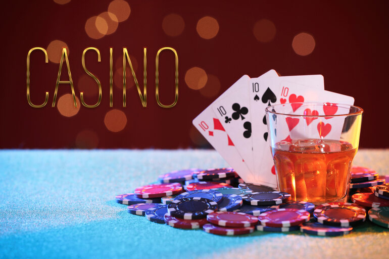 Casino night party table with playing cards, poker chips, and a glass of homebrew