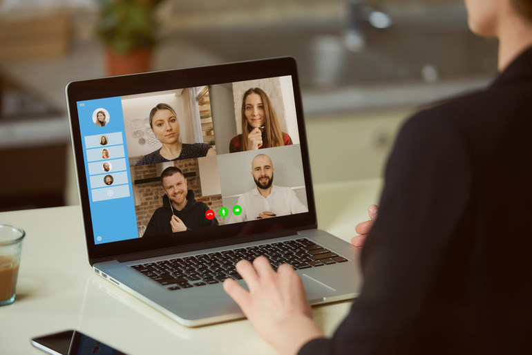 A person using a laptop for a live video chat with four participants