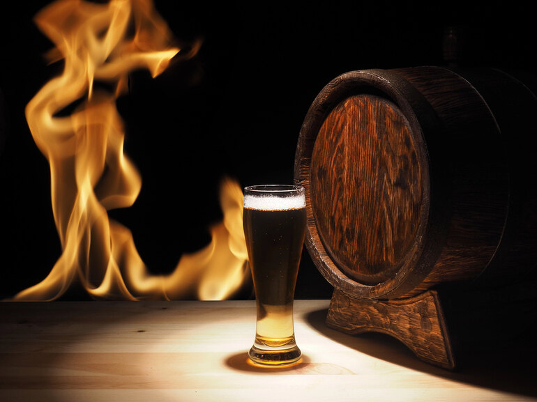 A pint of beer next to a wooden barrel served for a Warcraft gaming session