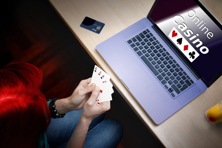A gamer is playing online casino on a laptop with a huge bonus on her first deposit