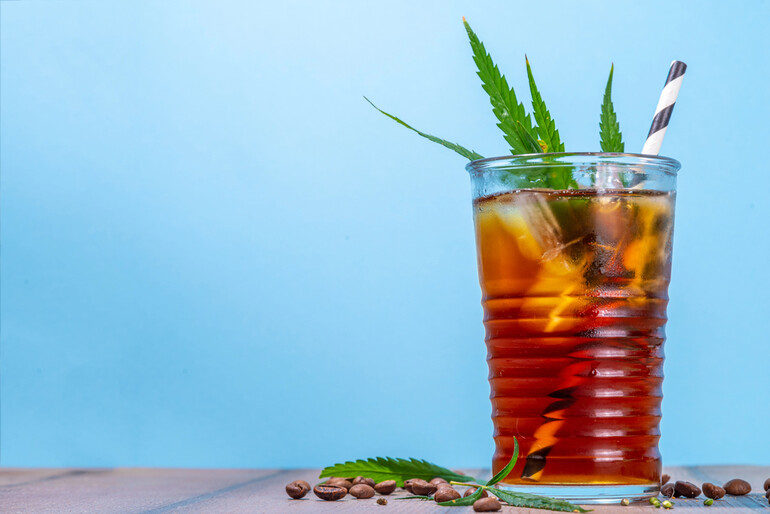 A glass of a popular iced hemp-infused drink garnished with hemp leaves