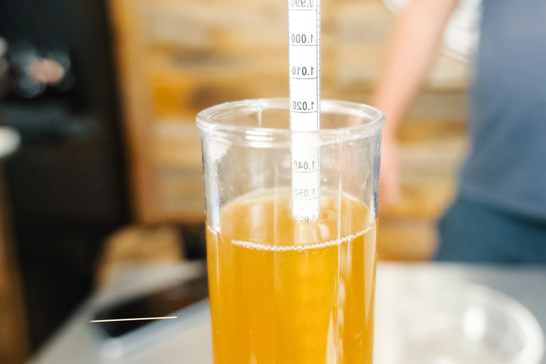 Hydrometer floating in homebrewed lager to measure alcohol content before a soccer match day